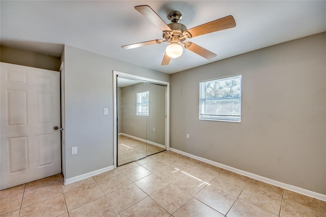 unfurnished bedroom with ceiling fan, light tile patterned flooring, and a closet