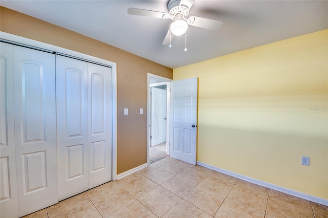 unfurnished bedroom featuring ceiling fan, a closet, and light tile patterned floors