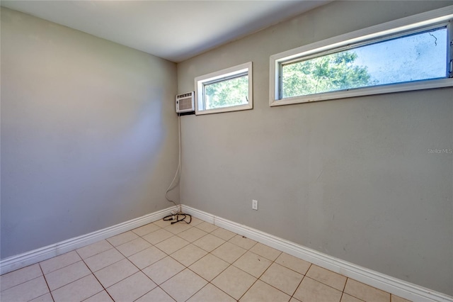 empty room featuring a wall mounted AC and light tile patterned flooring