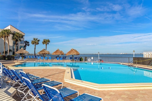 view of swimming pool with a water view and a patio