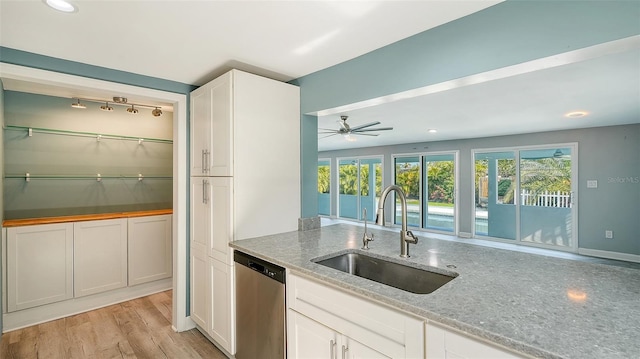 kitchen featuring a wealth of natural light, white cabinetry, sink, and stainless steel dishwasher