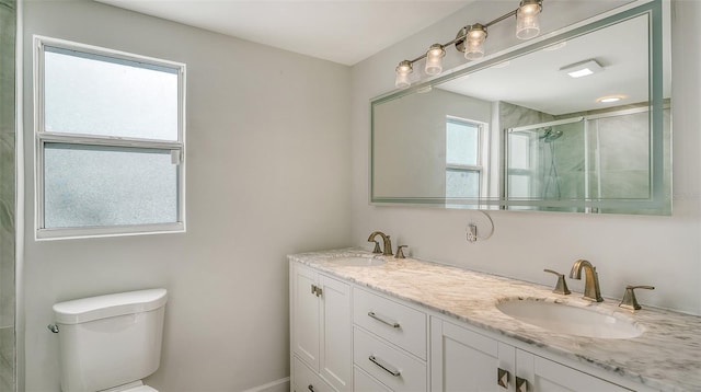 bathroom featuring vanity, toilet, and an enclosed shower