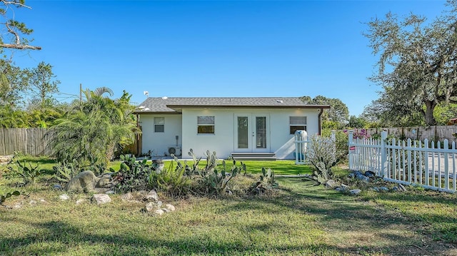 rear view of property featuring a lawn and french doors