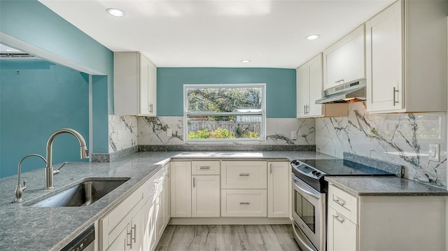 kitchen with decorative backsplash, appliances with stainless steel finishes, sink, light hardwood / wood-style flooring, and white cabinetry