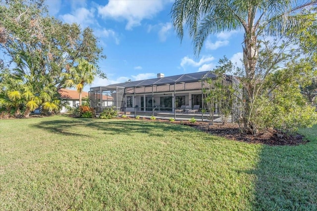 back of property featuring a yard and glass enclosure