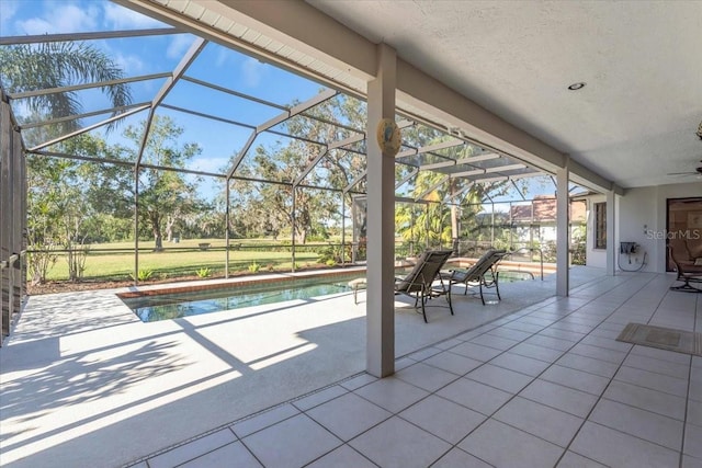 outdoor pool featuring a patio area, glass enclosure, and a ceiling fan