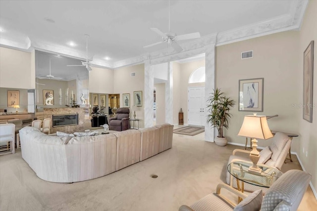 living area featuring ceiling fan, carpet flooring, visible vents, and ornamental molding