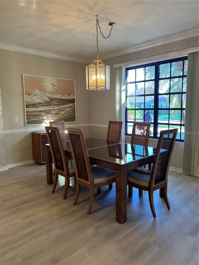 dining room featuring plenty of natural light, baseboards, light wood-type flooring, and ornamental molding