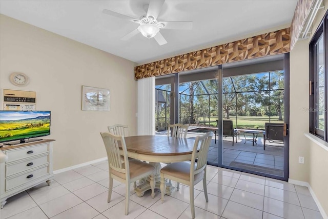 dining area with light tile patterned flooring, ceiling fan, baseboards, and a sunroom