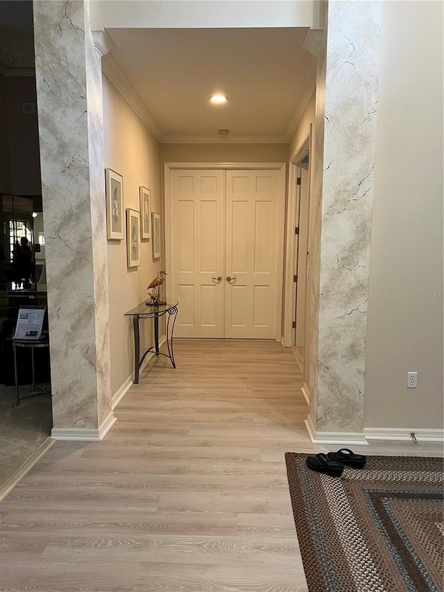 hall featuring baseboards, wood finished floors, and crown molding