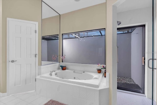 bathroom featuring tile patterned floors, a jetted tub, and a stall shower