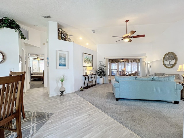 carpeted living room with a textured ceiling and high vaulted ceiling