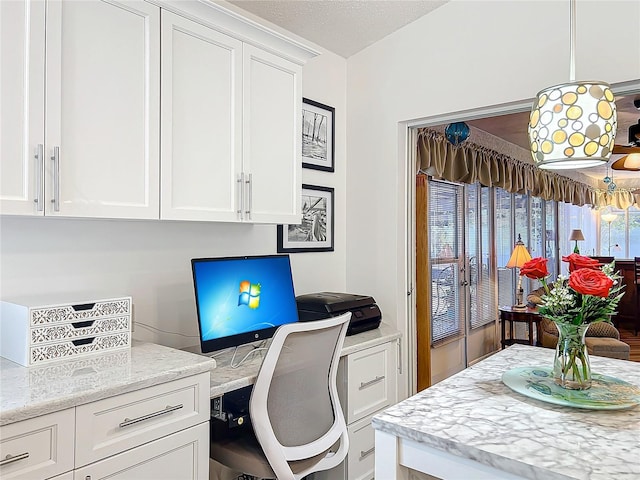 office featuring built in desk and a textured ceiling