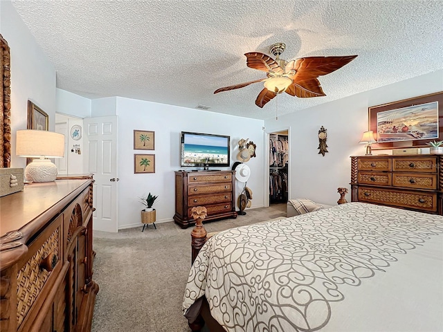 carpeted bedroom featuring ceiling fan, a spacious closet, a textured ceiling, and a closet