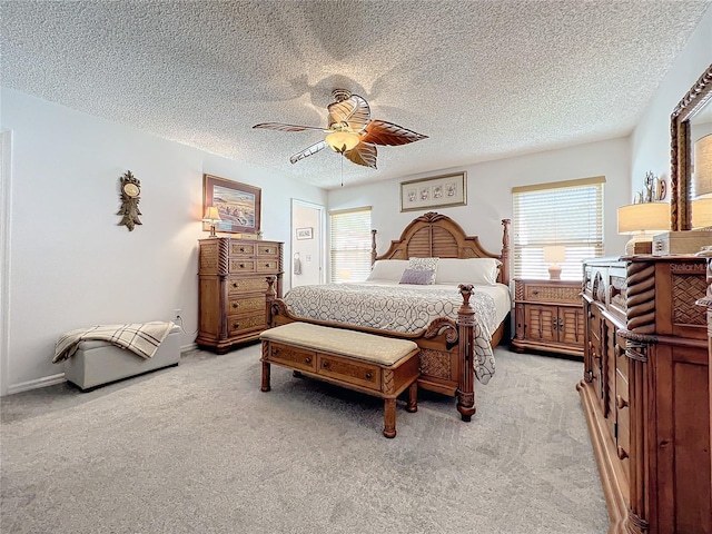 bedroom featuring ceiling fan, light colored carpet, and a textured ceiling