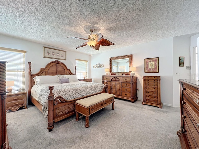 carpeted bedroom with ceiling fan, a textured ceiling, and multiple windows