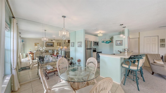 dining room with ceiling fan, sink, light tile patterned floors, and a textured ceiling