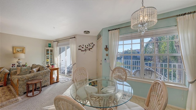 carpeted dining room featuring an inviting chandelier