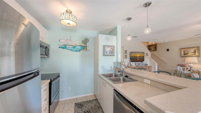 kitchen with pendant lighting, white cabinets, sink, and stainless steel appliances