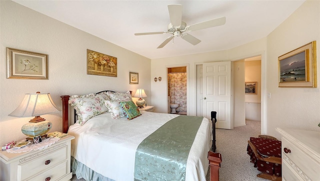 carpeted bedroom with ensuite bath and ceiling fan