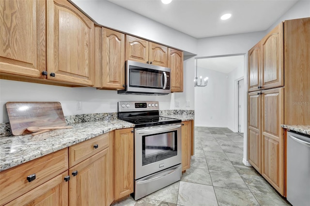 kitchen featuring a notable chandelier, light stone countertops, and appliances with stainless steel finishes