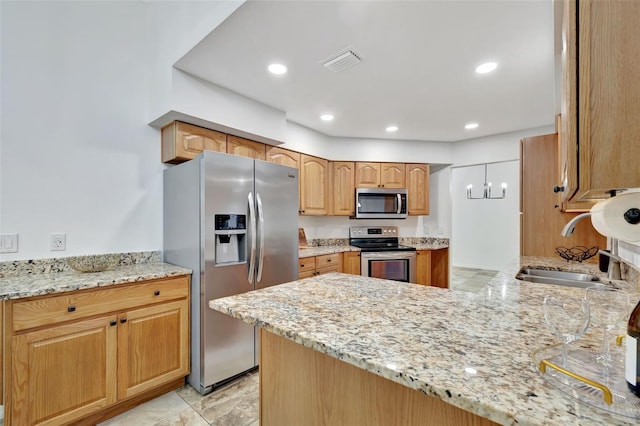 kitchen featuring light stone counters, sink, kitchen peninsula, and stainless steel appliances