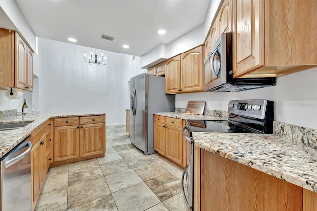 kitchen with light stone countertops, sink, hanging light fixtures, a chandelier, and appliances with stainless steel finishes