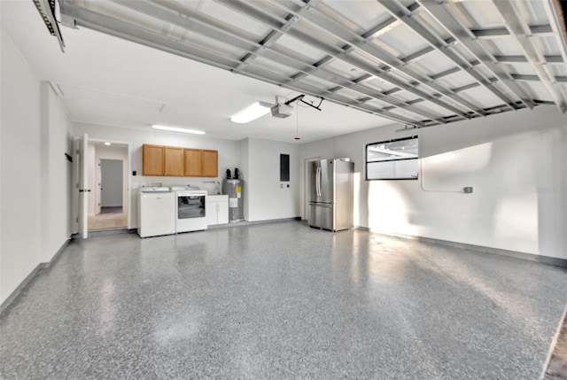 garage featuring washer and clothes dryer, a garage door opener, stainless steel refrigerator, and water heater