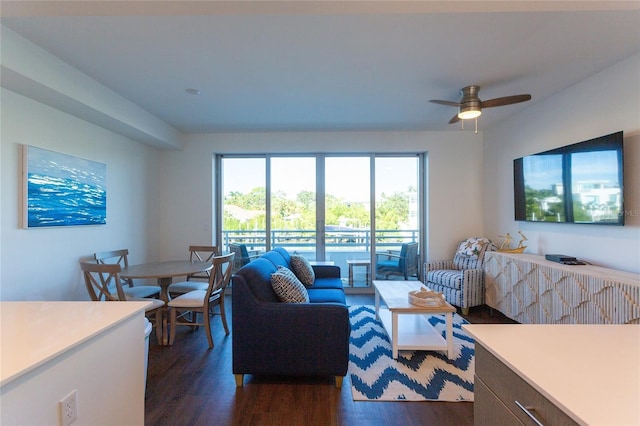 living room featuring ceiling fan and dark wood-type flooring