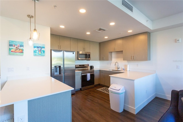 kitchen with sink, dark wood-type flooring, kitchen peninsula, pendant lighting, and appliances with stainless steel finishes