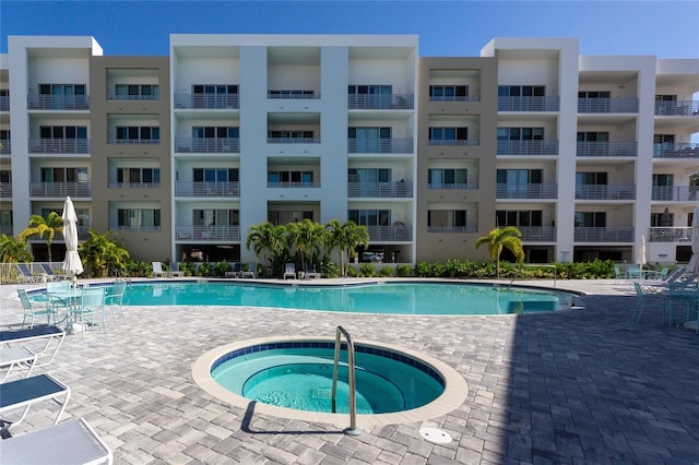 view of swimming pool featuring a patio and a hot tub