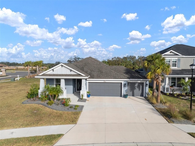 view of front facade featuring a garage, a front lawn, and covered porch