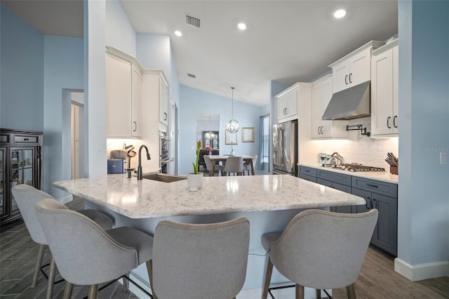 kitchen featuring sink, tasteful backsplash, hanging light fixtures, appliances with stainless steel finishes, and white cabinets