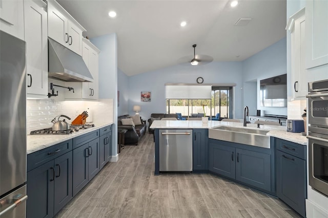 kitchen with sink, light hardwood / wood-style flooring, appliances with stainless steel finishes, white cabinets, and backsplash