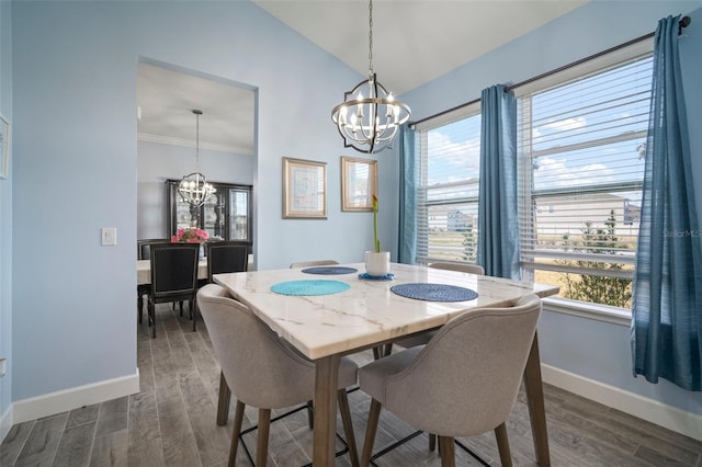 dining space featuring an inviting chandelier, crown molding, dark wood-type flooring, and vaulted ceiling