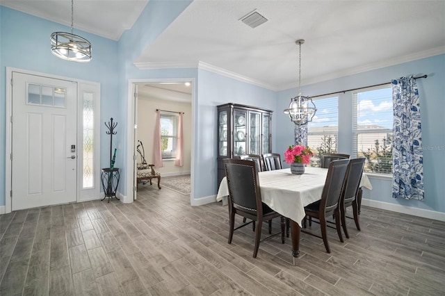 dining room featuring an inviting chandelier, wood-type flooring, and crown molding