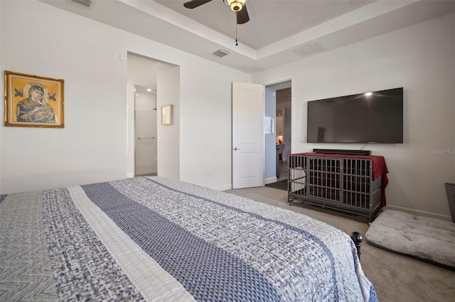 carpeted bedroom featuring a raised ceiling and ceiling fan