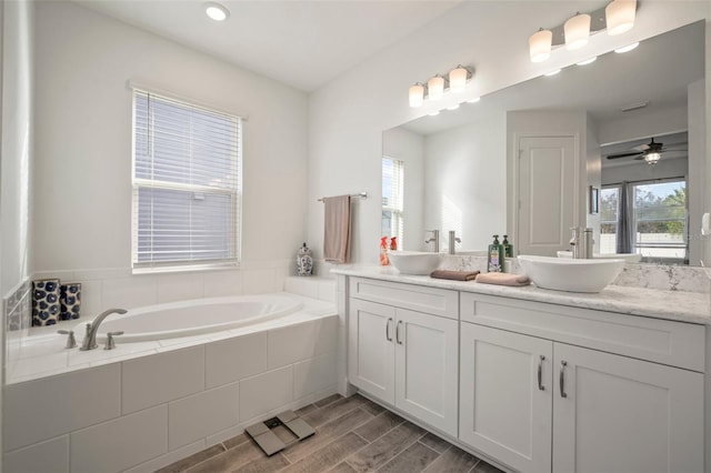 bathroom featuring vanity, tiled bath, and plenty of natural light