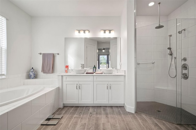 bathroom featuring vanity, independent shower and bath, and hardwood / wood-style floors