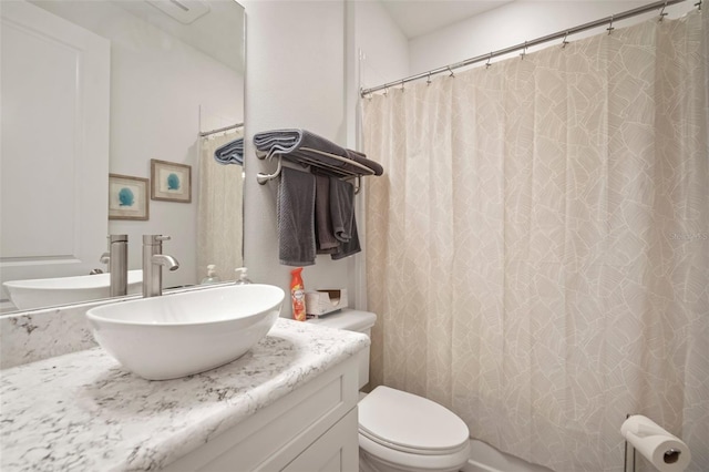 bathroom featuring walk in shower, vanity, and toilet