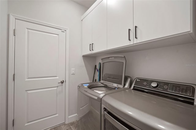 washroom with cabinets, independent washer and dryer, and light hardwood / wood-style floors