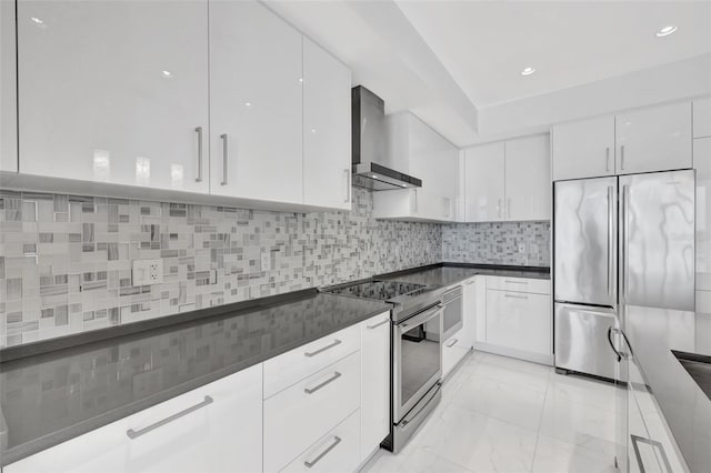 kitchen with white cabinetry, wall chimney range hood, backsplash, and stainless steel appliances