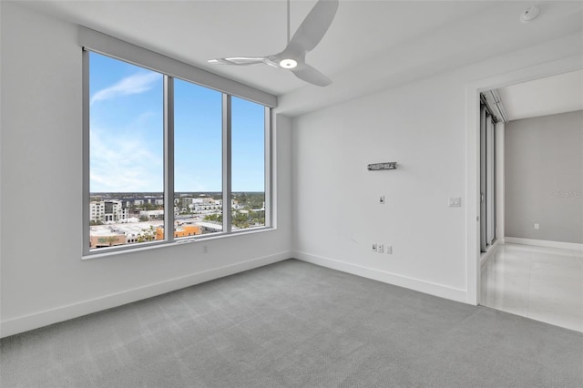 carpeted spare room featuring ceiling fan