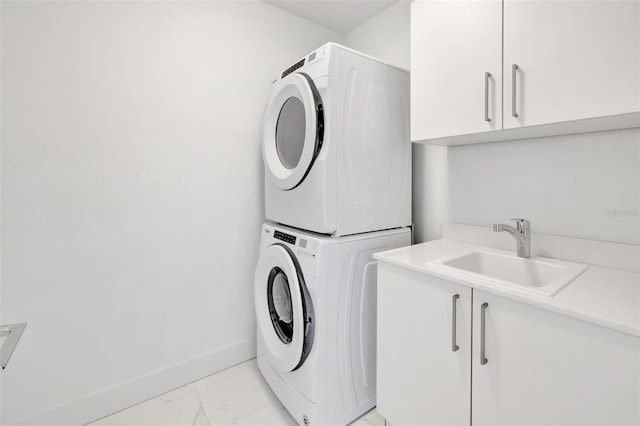 laundry area with cabinets, sink, and stacked washer and clothes dryer