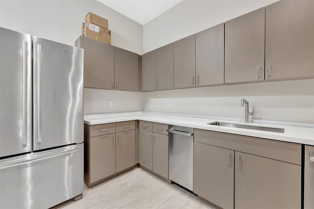 kitchen with stainless steel appliances, sink, and gray cabinetry