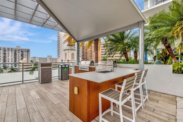 wooden deck featuring a grill, area for grilling, and a wet bar