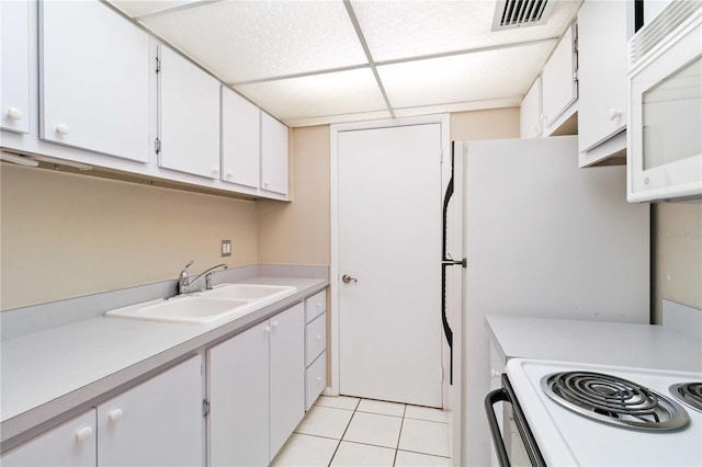 kitchen with light tile patterned floors, light countertops, visible vents, white cabinetry, and a sink