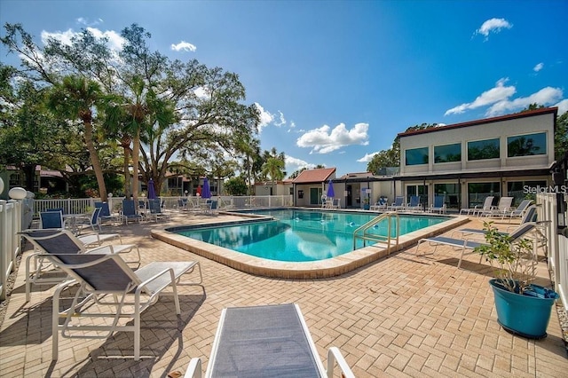 pool with a patio and fence