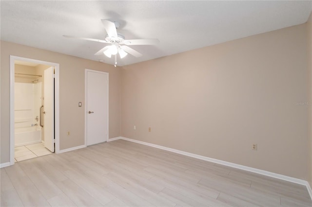 spare room with ceiling fan, light wood finished floors, and baseboards