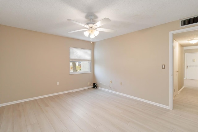 unfurnished room featuring light wood finished floors, visible vents, a ceiling fan, a textured ceiling, and baseboards